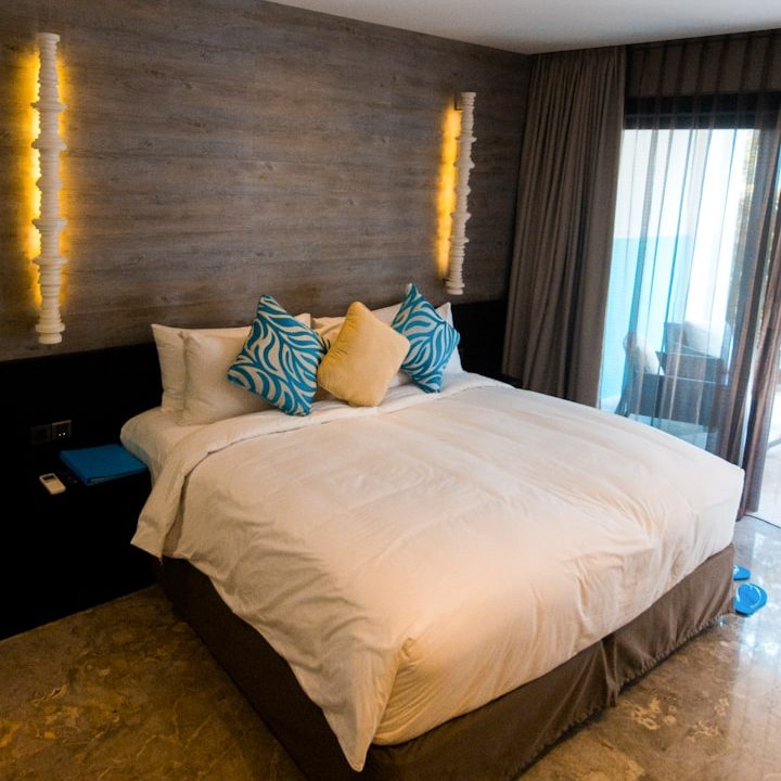 Modernes Hotelzimmer mit einem Bett, einem Schreibtisch und einer gemütlichen Sitzecke.